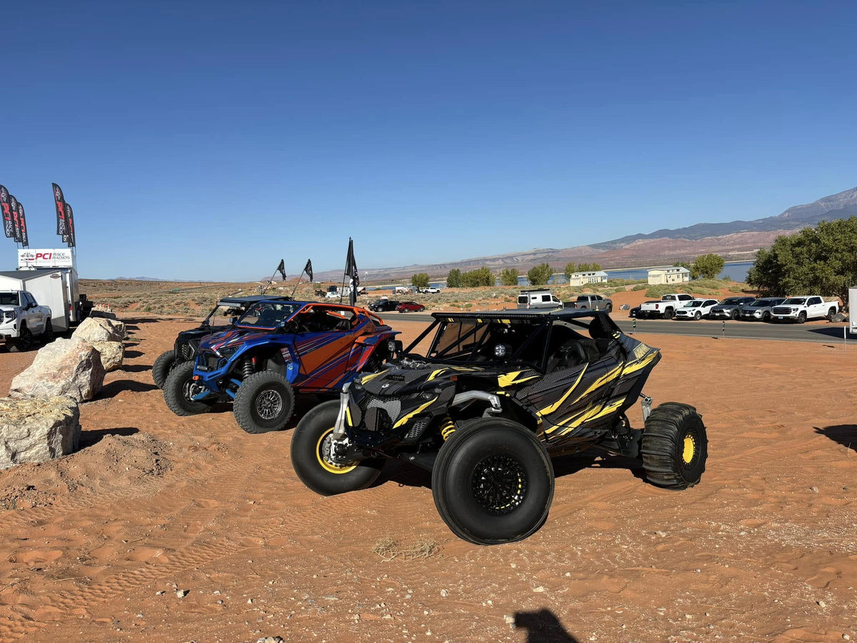 A row of sxs vehicles sitting out in the desert.