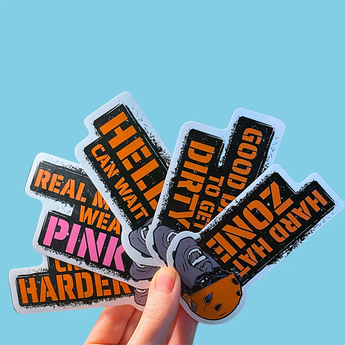 Hand holding multiple axel off road stickers